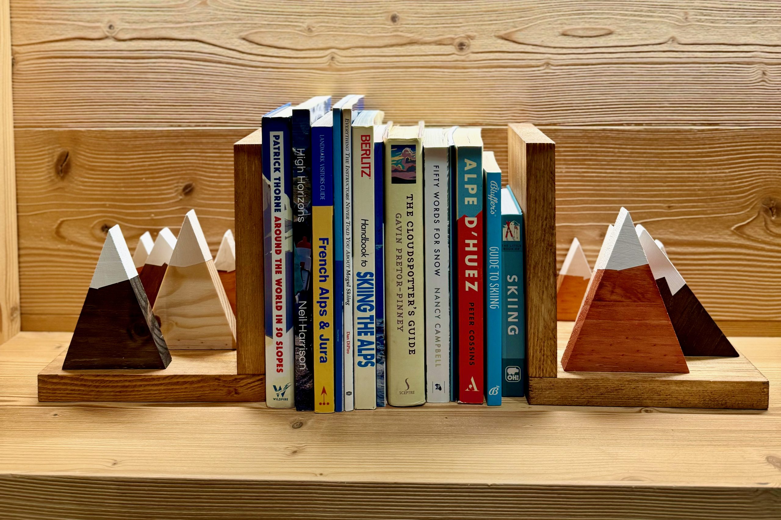 Skiing books on a bookshelf with mountain bookends