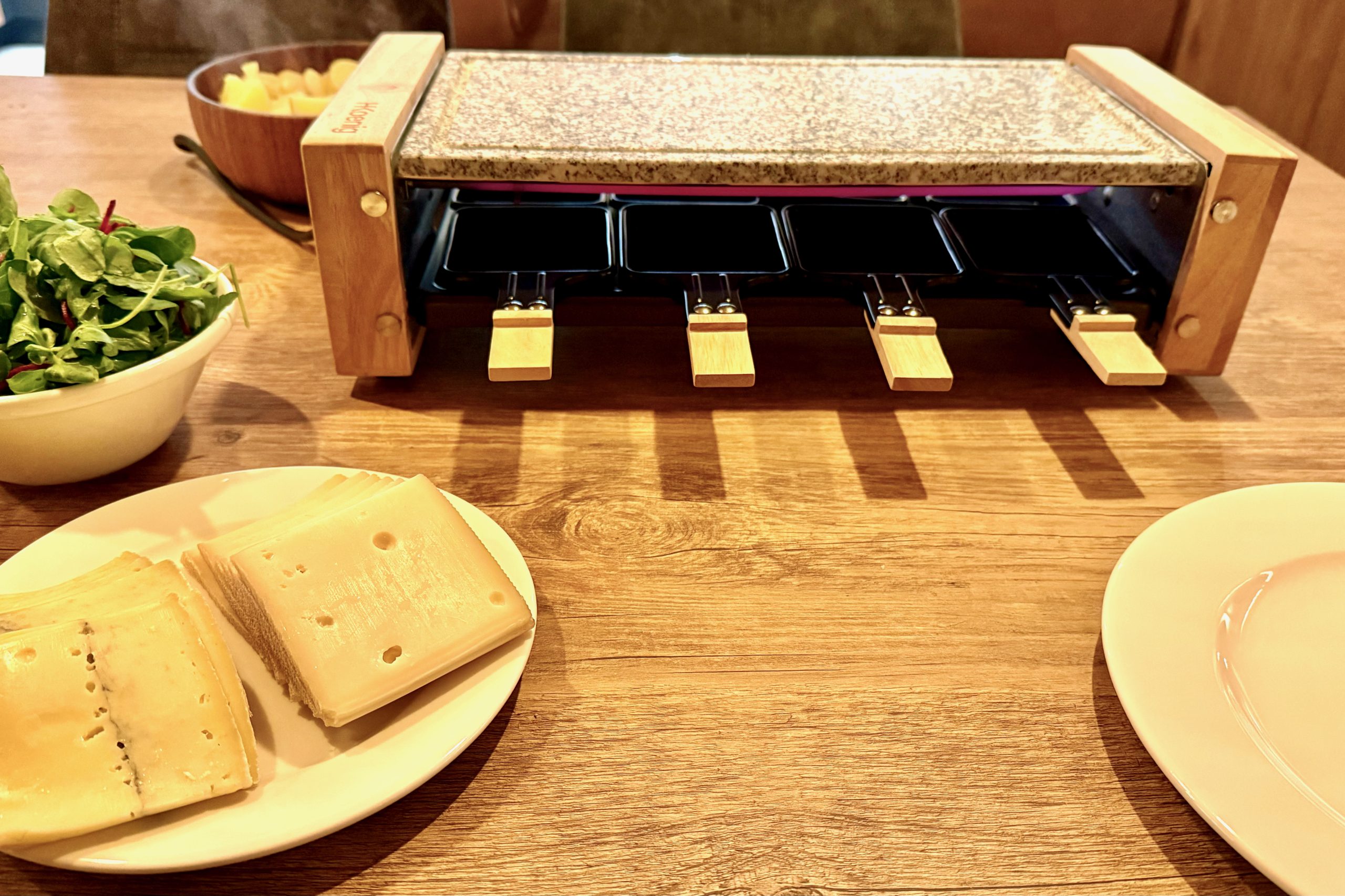 Raclette and salad on dining table